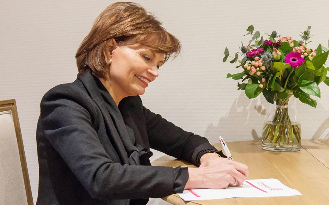 Rita Akkermans van Dynamis schrijft haar bevindingen neer aan een tafel met een roze kamerplantje